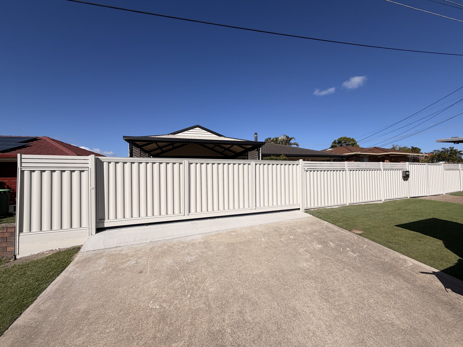 Colorbond fence with slat toppers and rolling gate